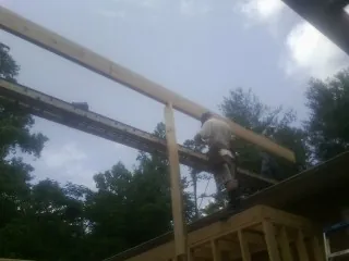 Carpenter setting a ridge beam over a new addition frame — Ice Dam Removal by Roofing Brothers in Juniata