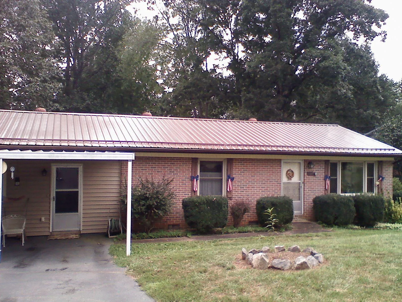 Bronze metal roof and carport on a brick ranch home — Roof Repair work by our crew in Juniata